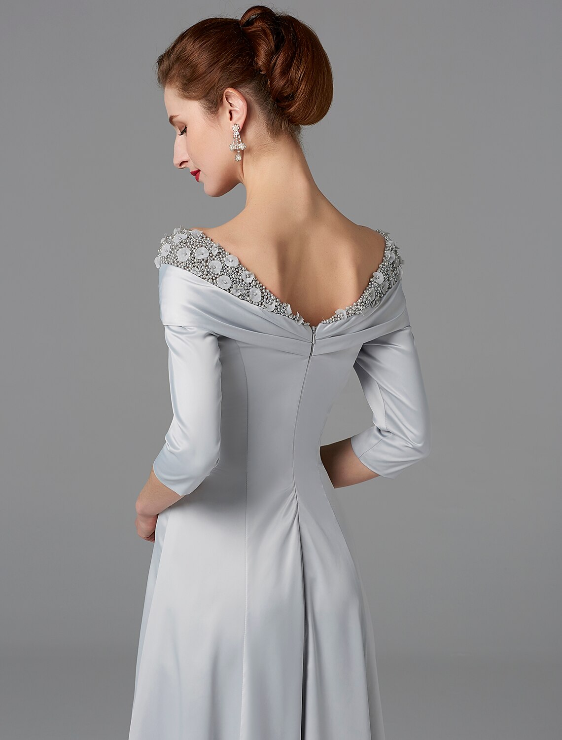 Detail of the sparkling satin fabric with delicate lace and crystal accents on the gown.