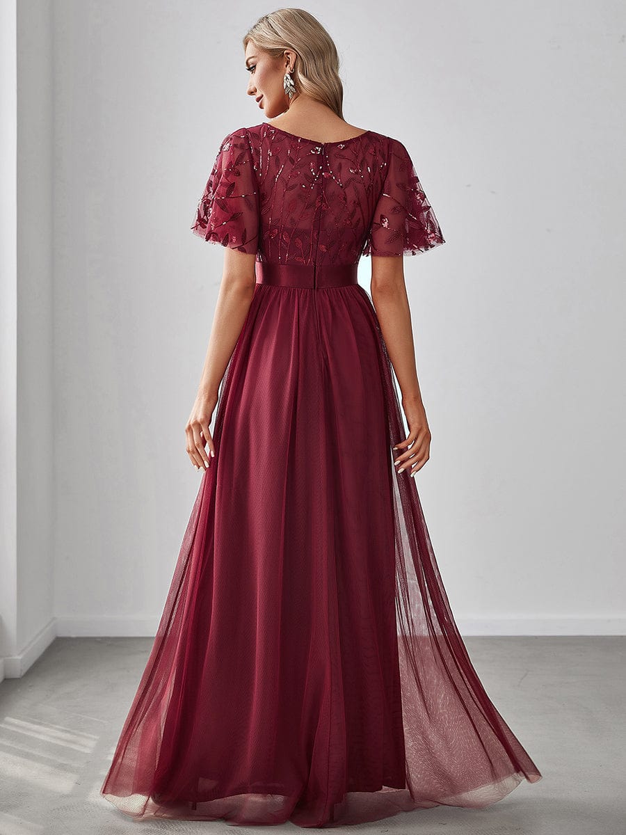 Back view of a woman in a burgundy Weitese sequin leaf maxi dress with sleeves.