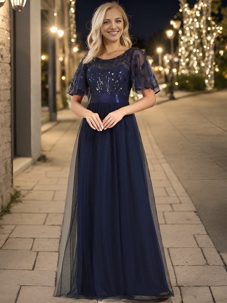 A woman in a navy blue Weitese A-line sequin leaf maxi dress with sleeves.