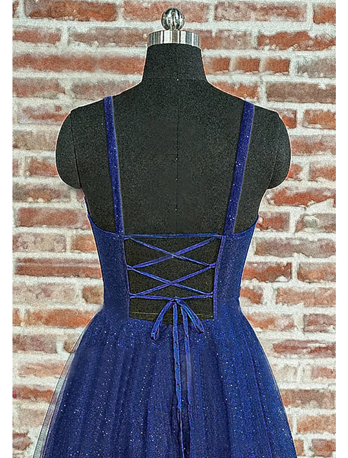 Model wearing a sparkling A-line sweetheart ball gown prom dress with glitter pleats and a backless design.