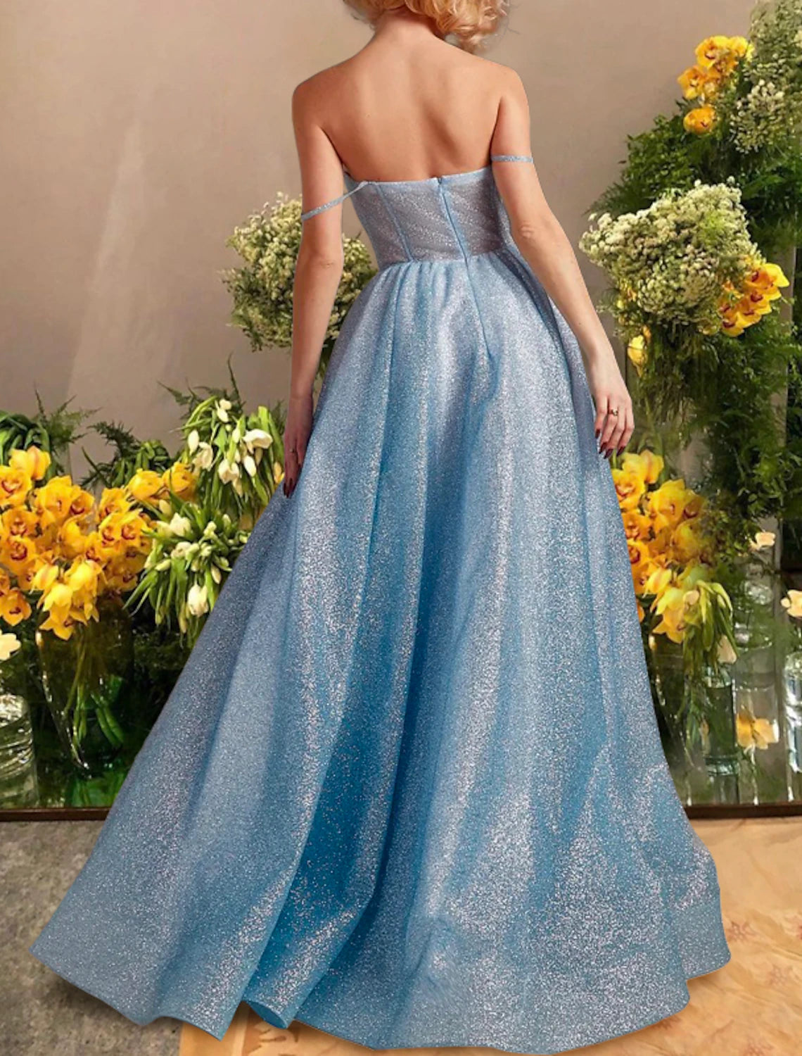 Back view of a black sparkling A-line formal gown with a flowing tulle skirt.