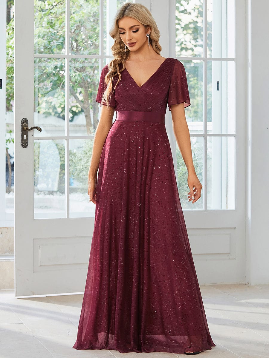 Model wearing a sparkling red A-line V-neck evening dress with short sleeves and a ribbon waist.