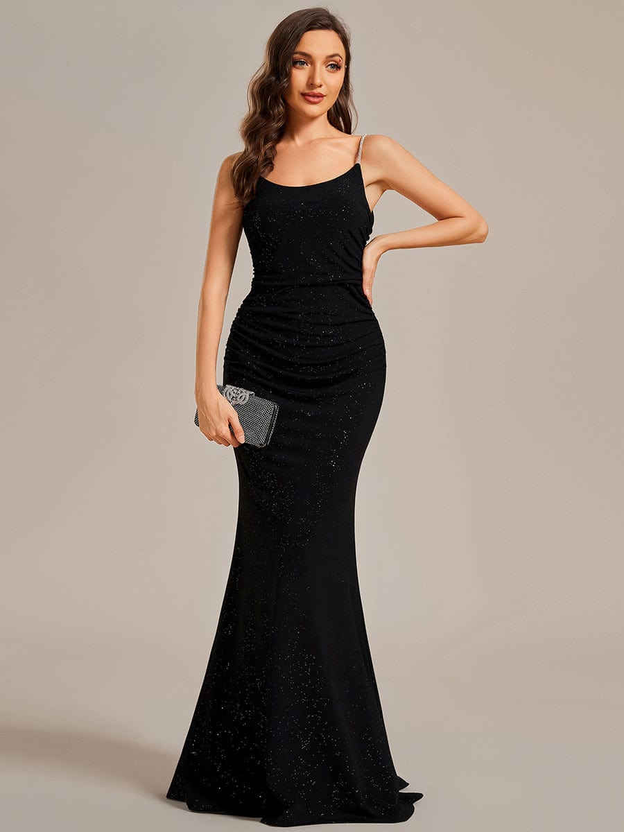 Front view of a woman wearing a black glitter bodycon evening dress with spaghetti straps and a U-neck.