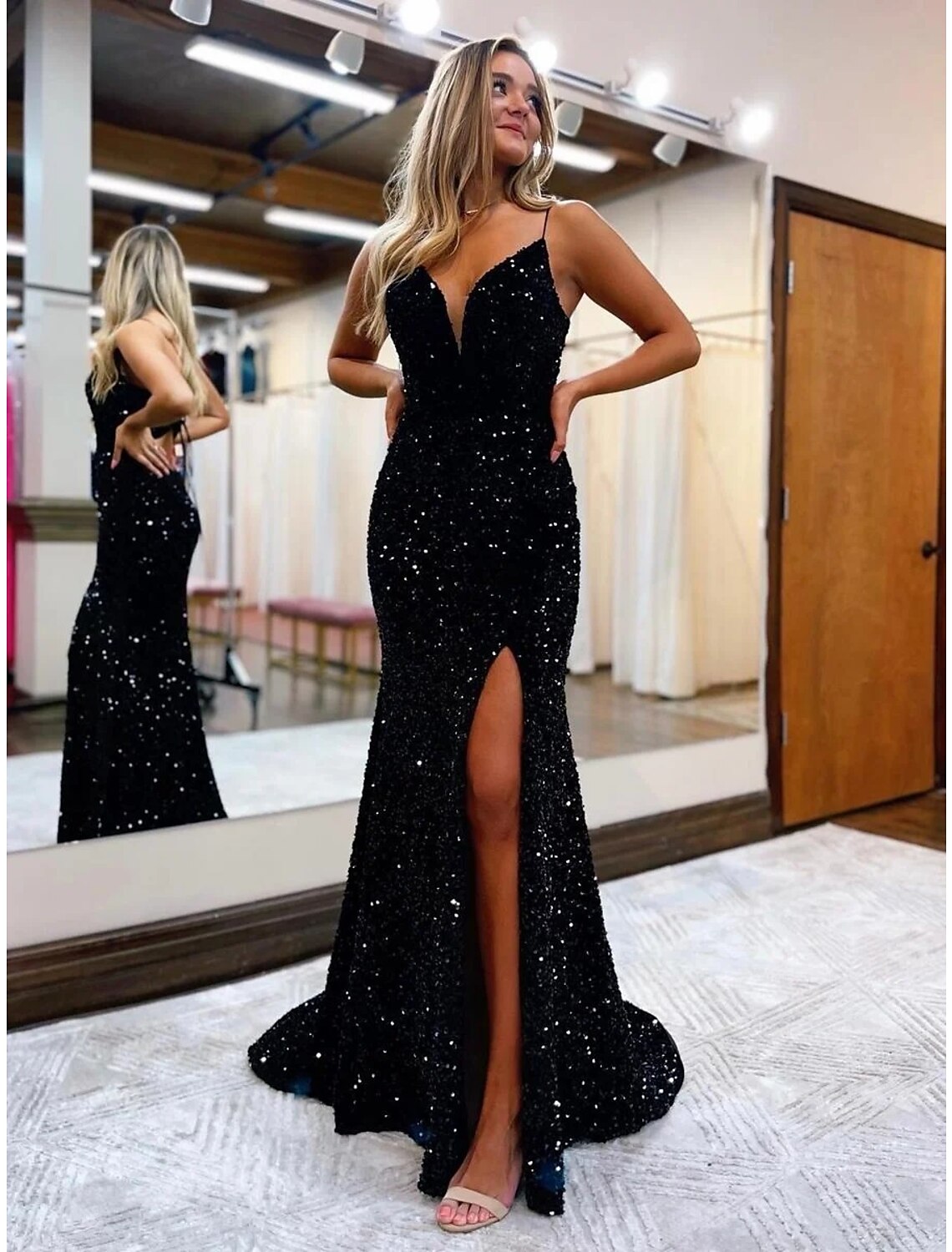 Woman in a sparkling V-neck sequined mermaid trumpet prom dress.