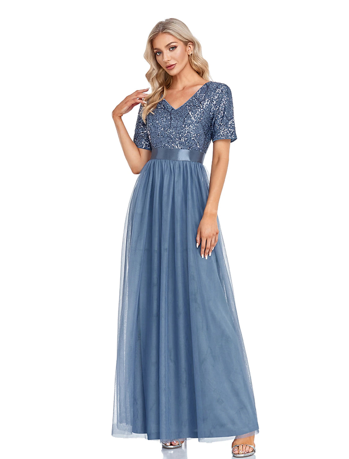 Full-length view of a woman in a sparkling navy A-line evening gown with short sleeves and a V-neck.