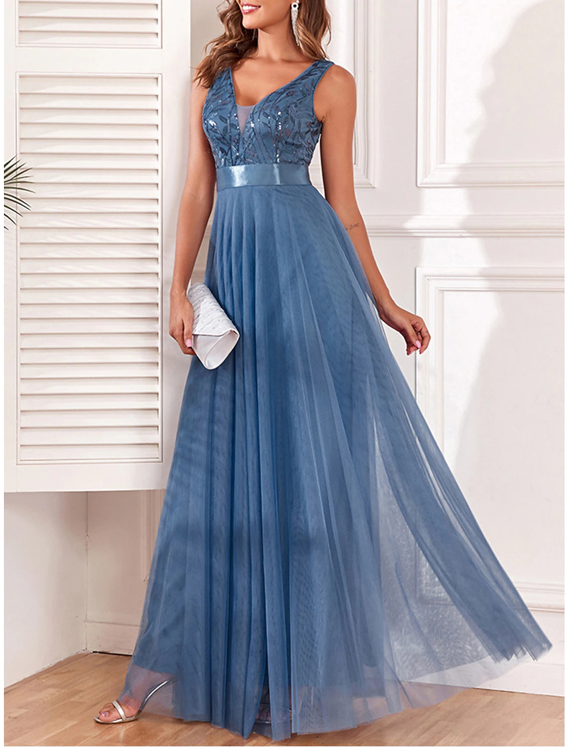 Woman wearing a sparkling blue sequin V-neck maxi dress, back view.