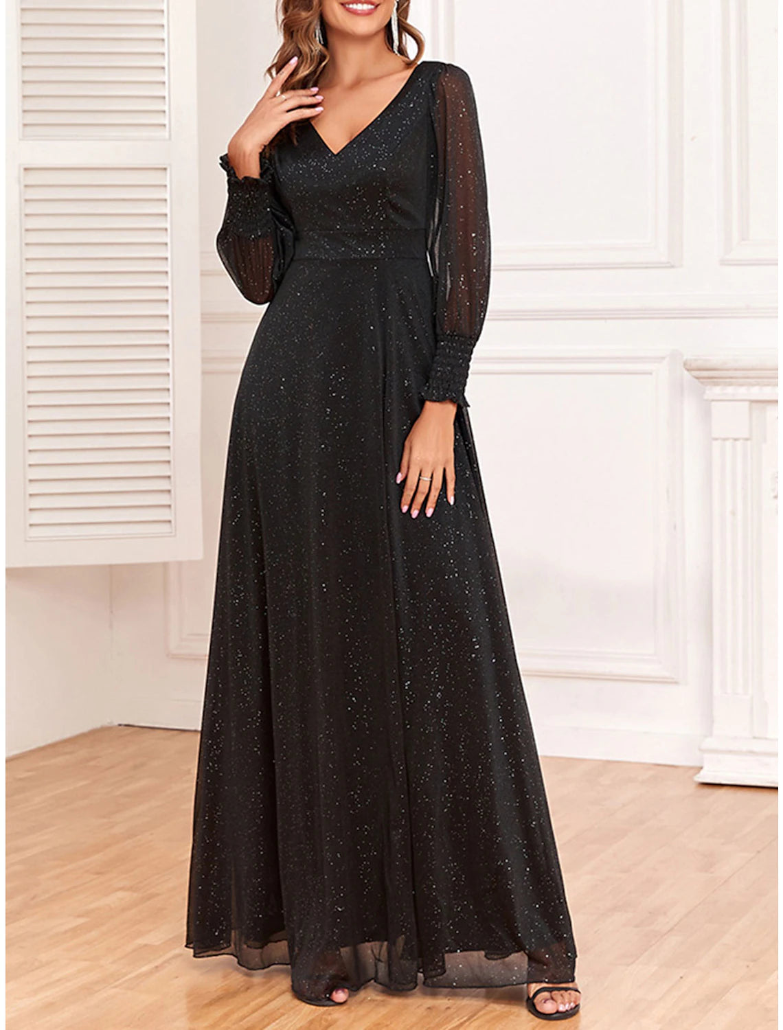 Close-up of the sparkly fabric and V-neckline of the black dress.