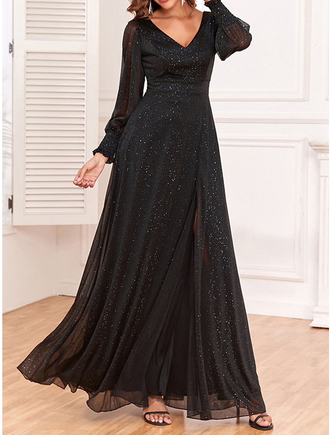 Woman walking in a black sparkly V-neck long sleeve maxi dress.