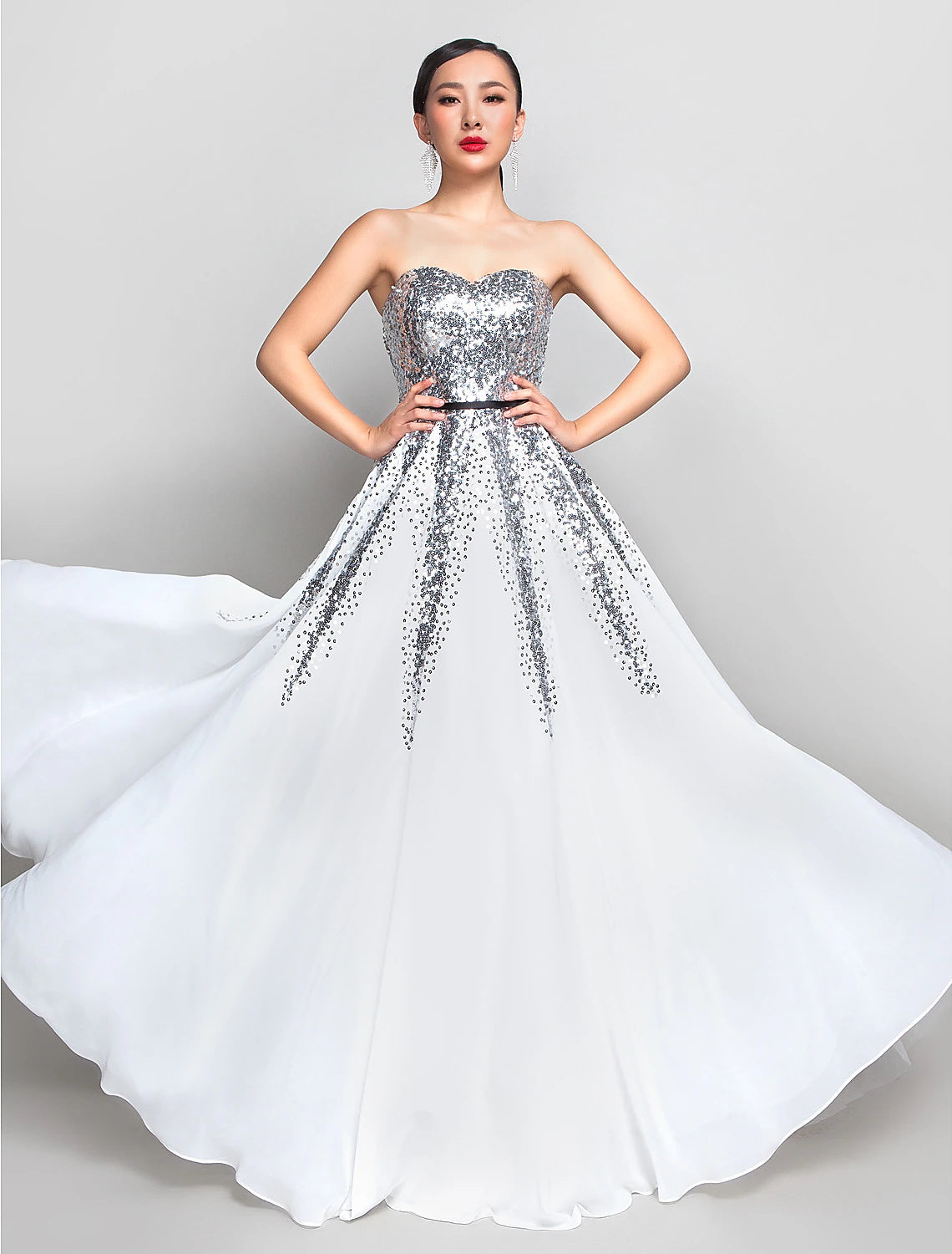Woman in a blue A-line sweetheart sequin chiffon floor-length dress with a sash.
