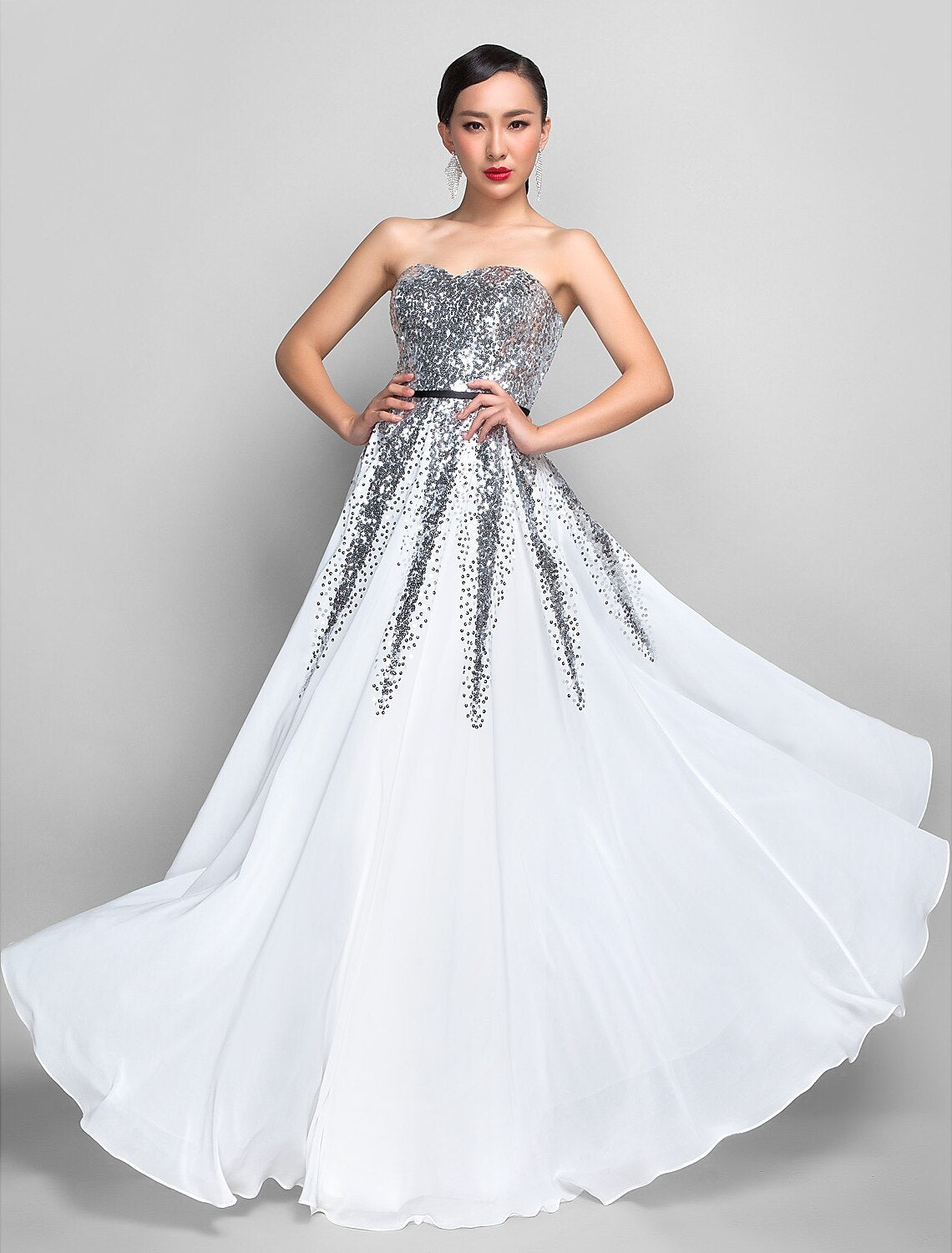 Woman in a green A-line sweetheart sequin chiffon floor-length dress with a sash.