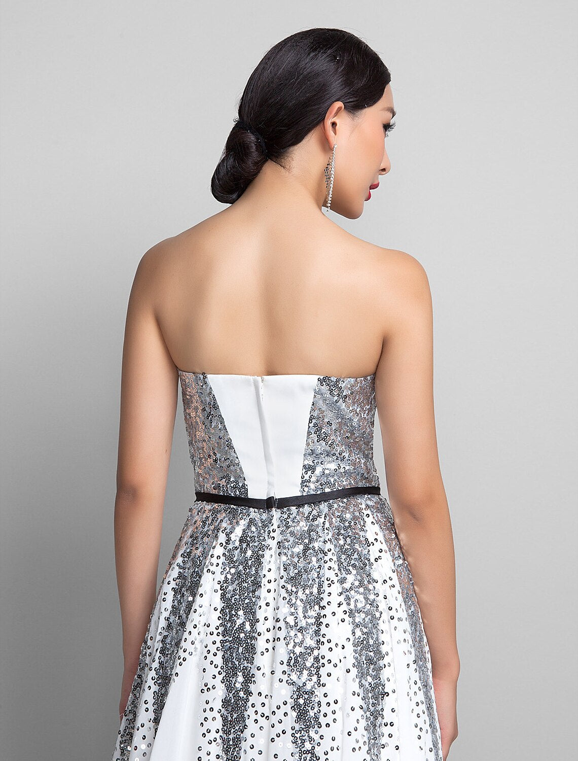 Back view of a woman in a blue A-line sweetheart sequin chiffon floor-length dress.