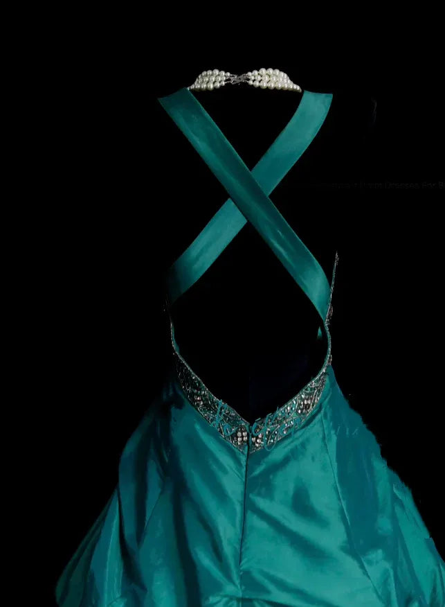 Back view of the teal satin ball gown, highlighting the elegant crisscross open back design.