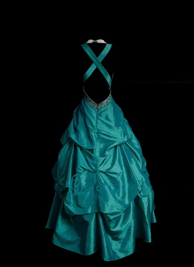 Side profile of the teal satin ball gown, showing the layered ruched bubble skirt and floor-length hem.