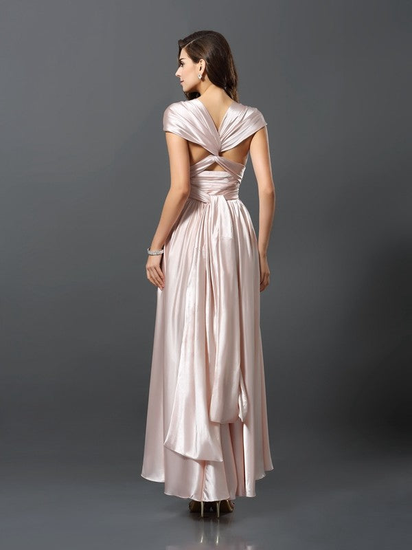 Back view of a model in a teal silk-like satin convertible dress, showcasing the high-low hem.