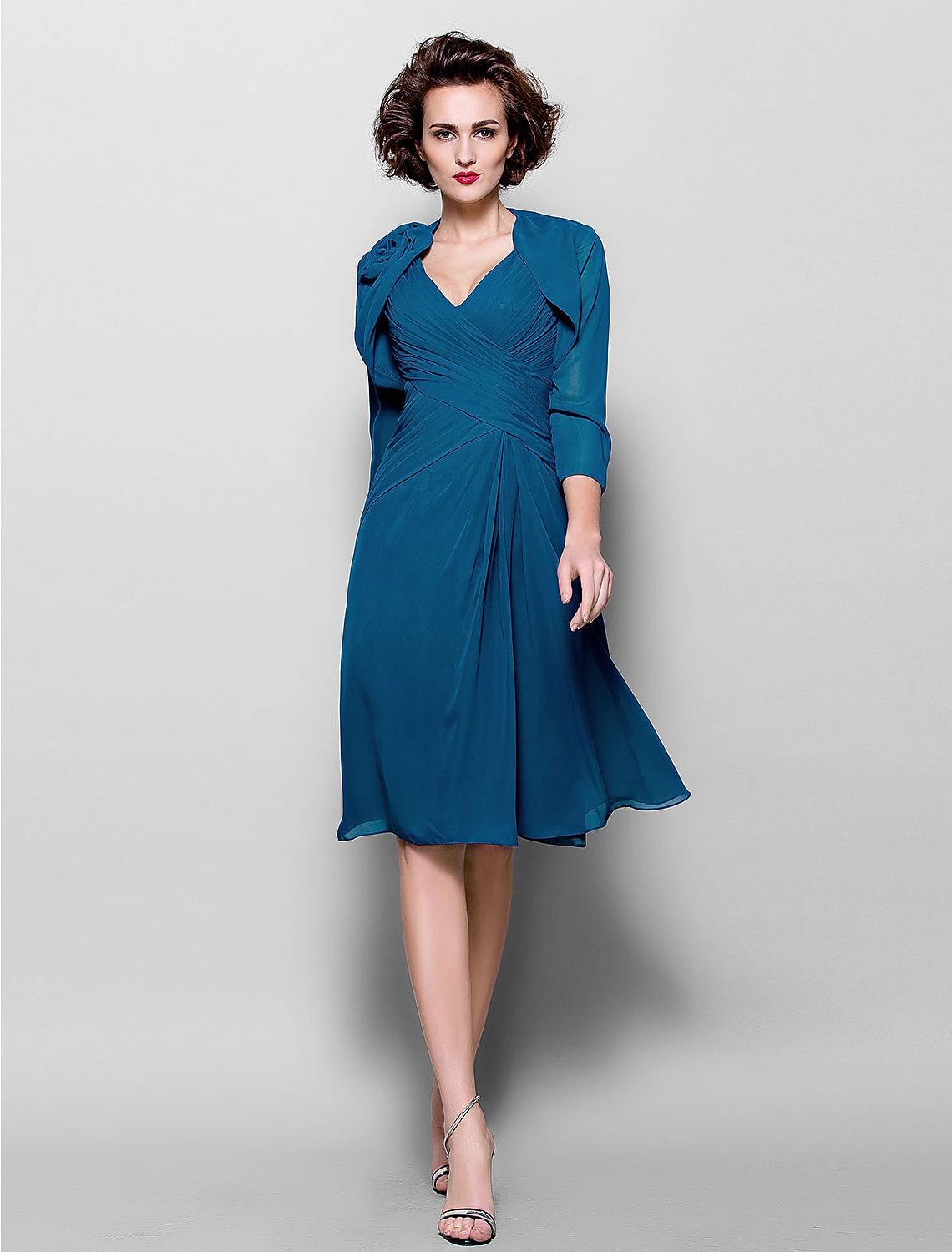 Woman wearing an A-line V-neck chiffon dress with a matching wrap.