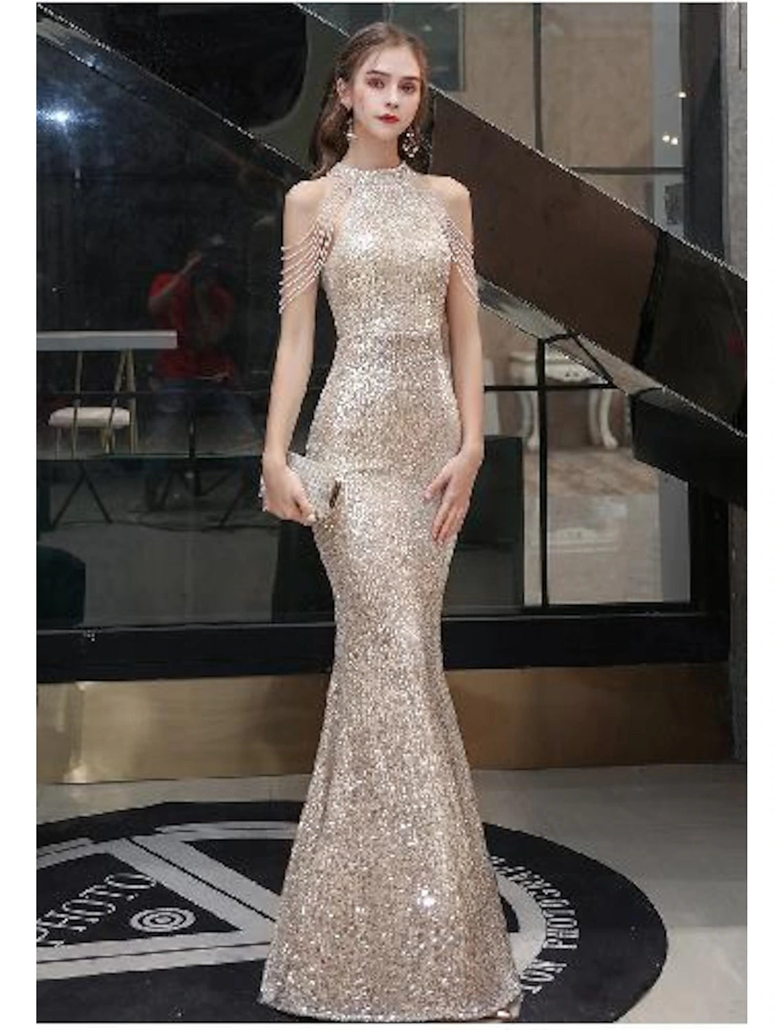 Woman wearing a dazzling Weitese mermaid sequin evening gown with a halter neck and floor-length design.