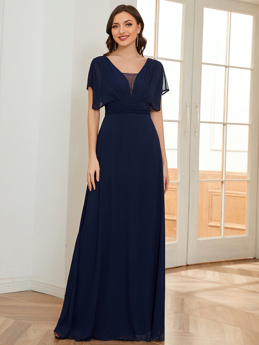 Woman wearing a navy blue Weitese A-line empire waist maxi chiffon dress.