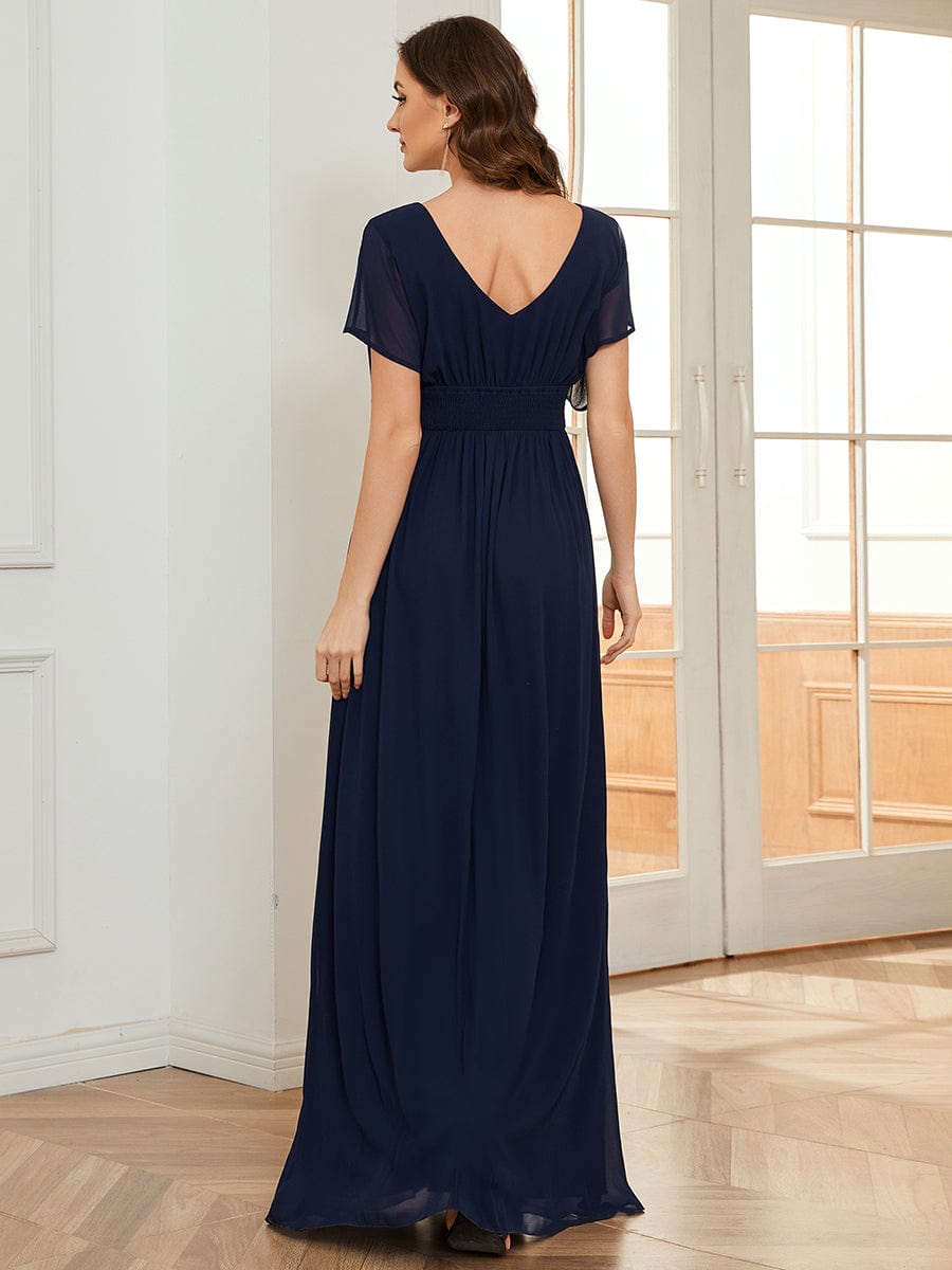 Woman in a navy blue Weitese chiffon evening dress.