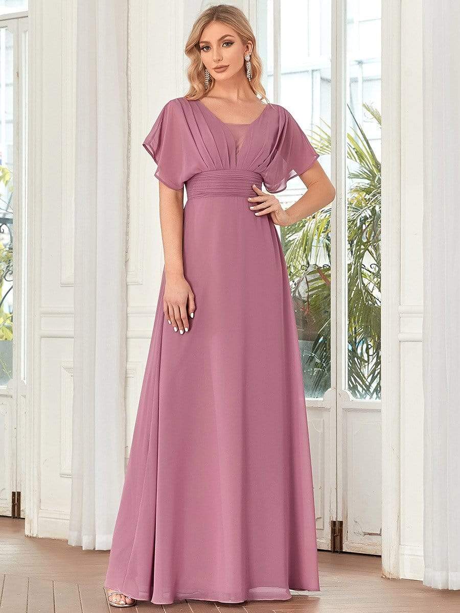 Full view of a woman in an olive green Weitese formal chiffon gown.