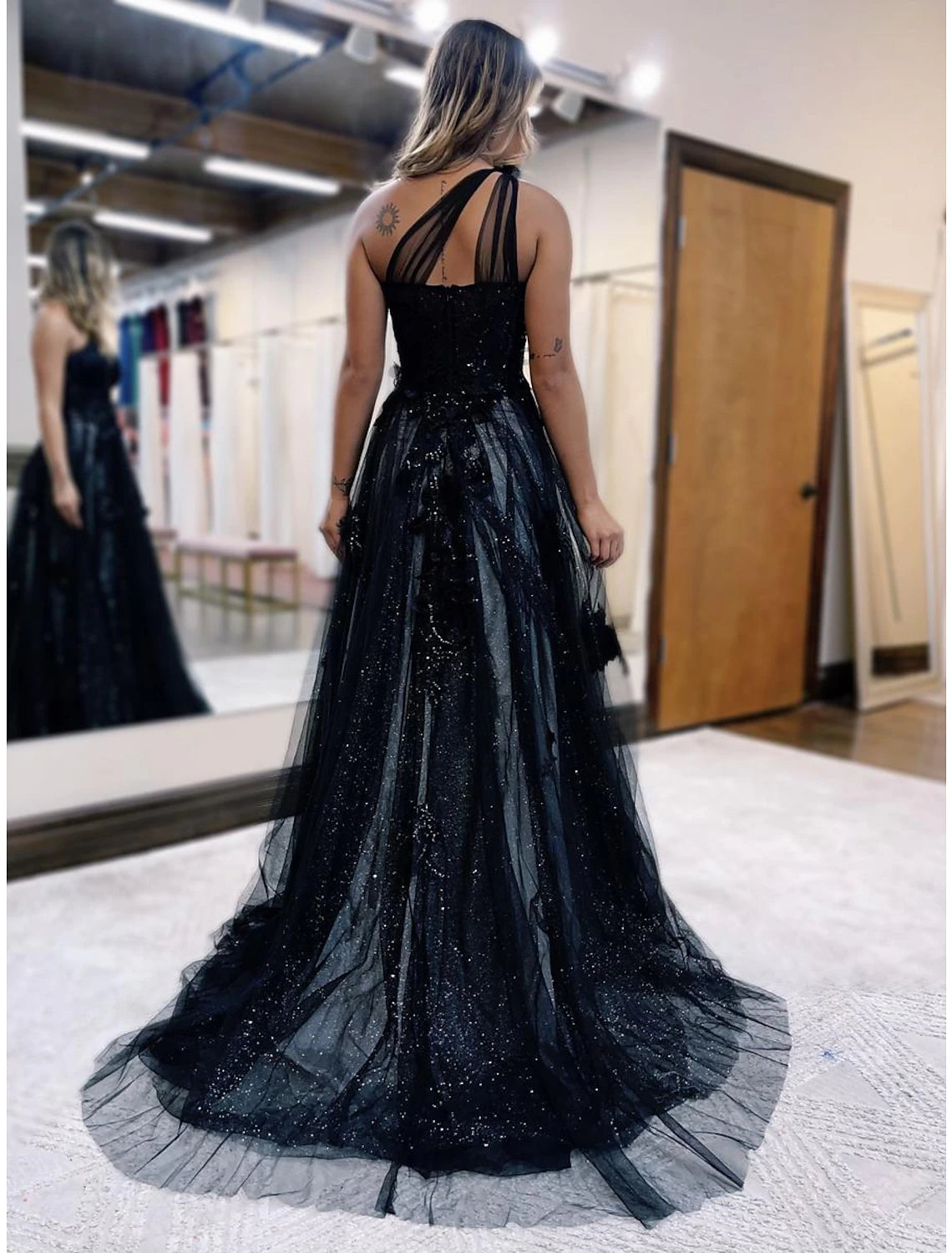 Side view of the black A-line gown, highlighting the sweep train.