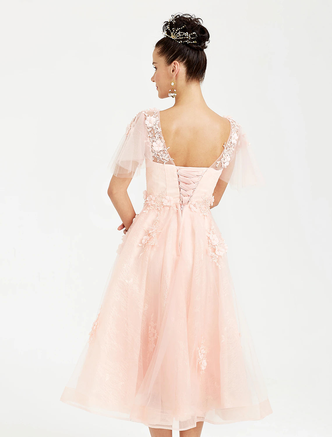 Side view of an elegant Weitese short sleeve tulle dress.