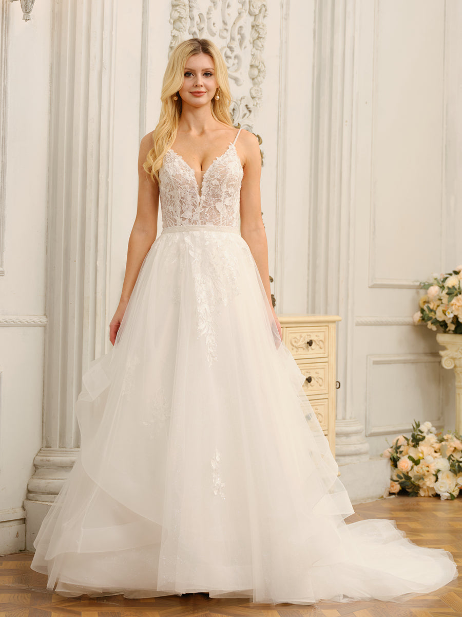 Full view of a bride in a white Weitese spaghetti strap V-neck wedding dress with appliques.