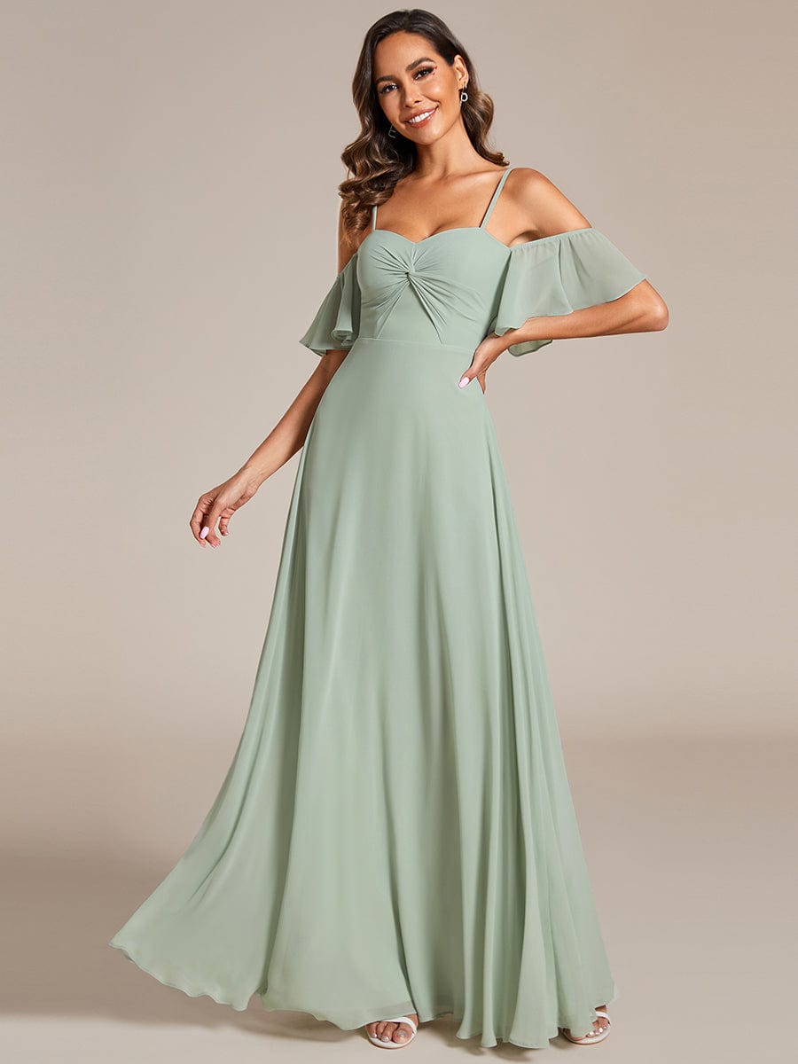 Model in a green Weitese A-line chiffon bridesmaid dress with spaghetti straps and knot detail.