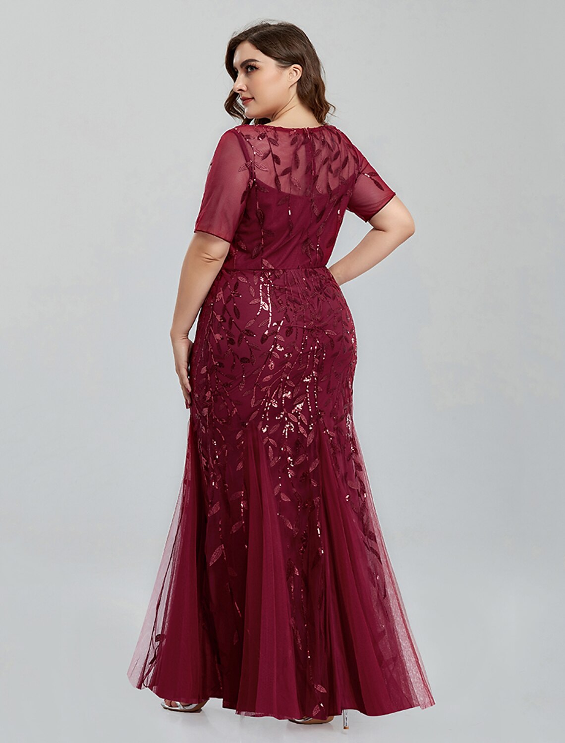 Side view of a woman in a Weitese embroidered tulle formal gown.