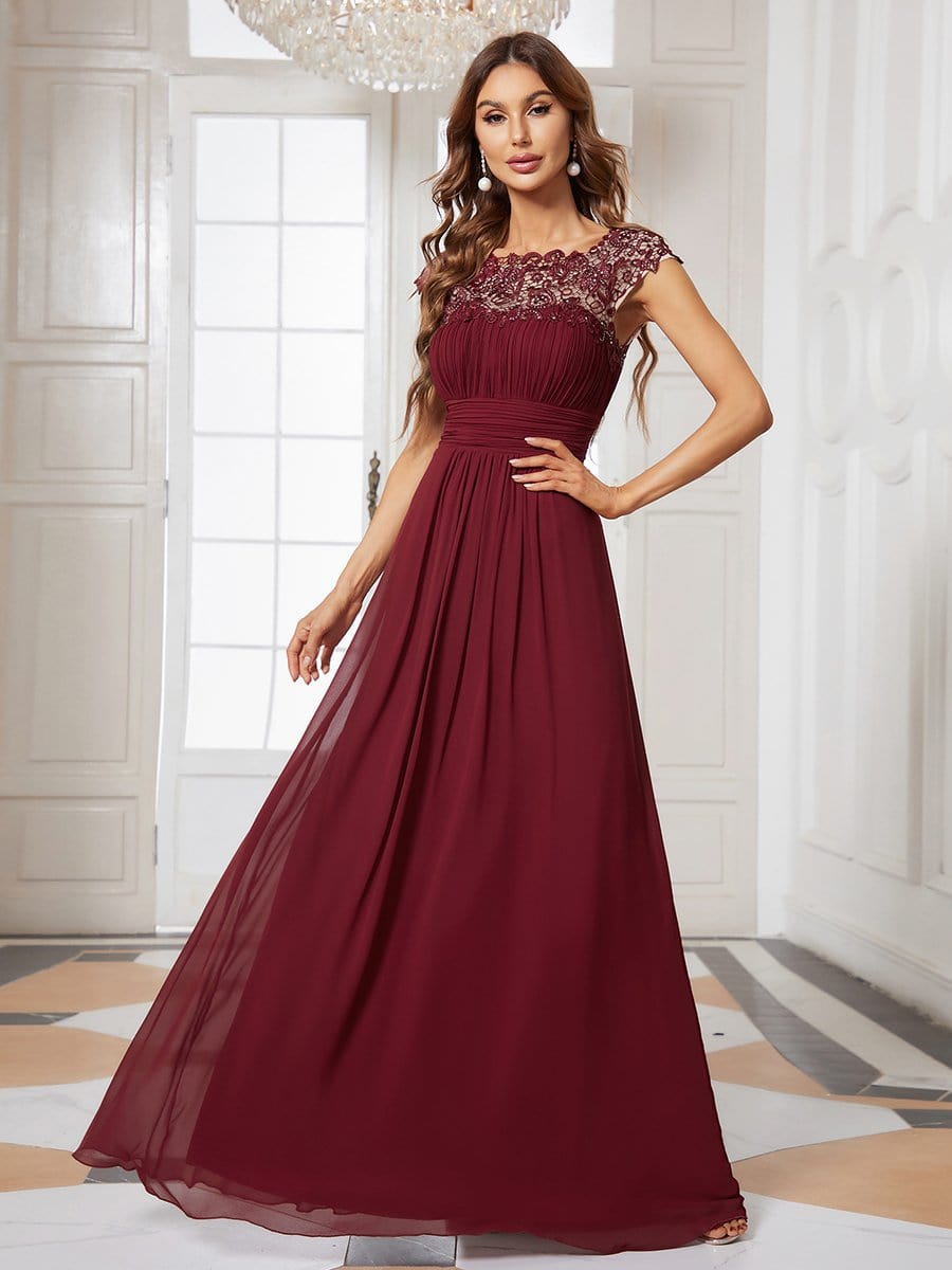 Bridesmaid dress with lace cap sleeves and flowing chiffon skirt in a soft color.