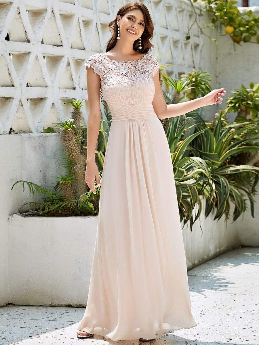 Woman in a black lace cap sleeve maxi bridesmaid dress.