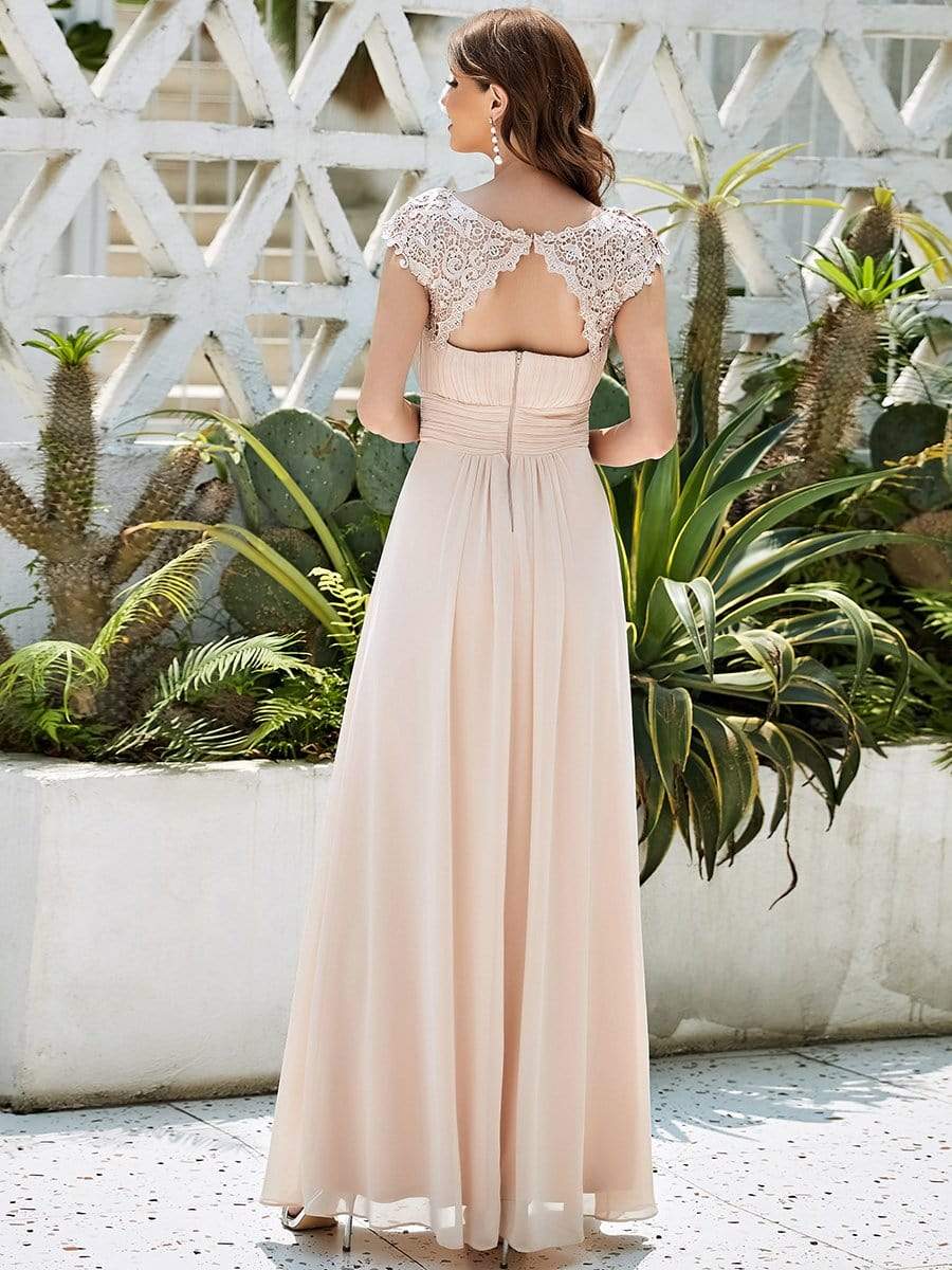 Woman in a dark blue lace cap sleeve maxi bridesmaid dress.