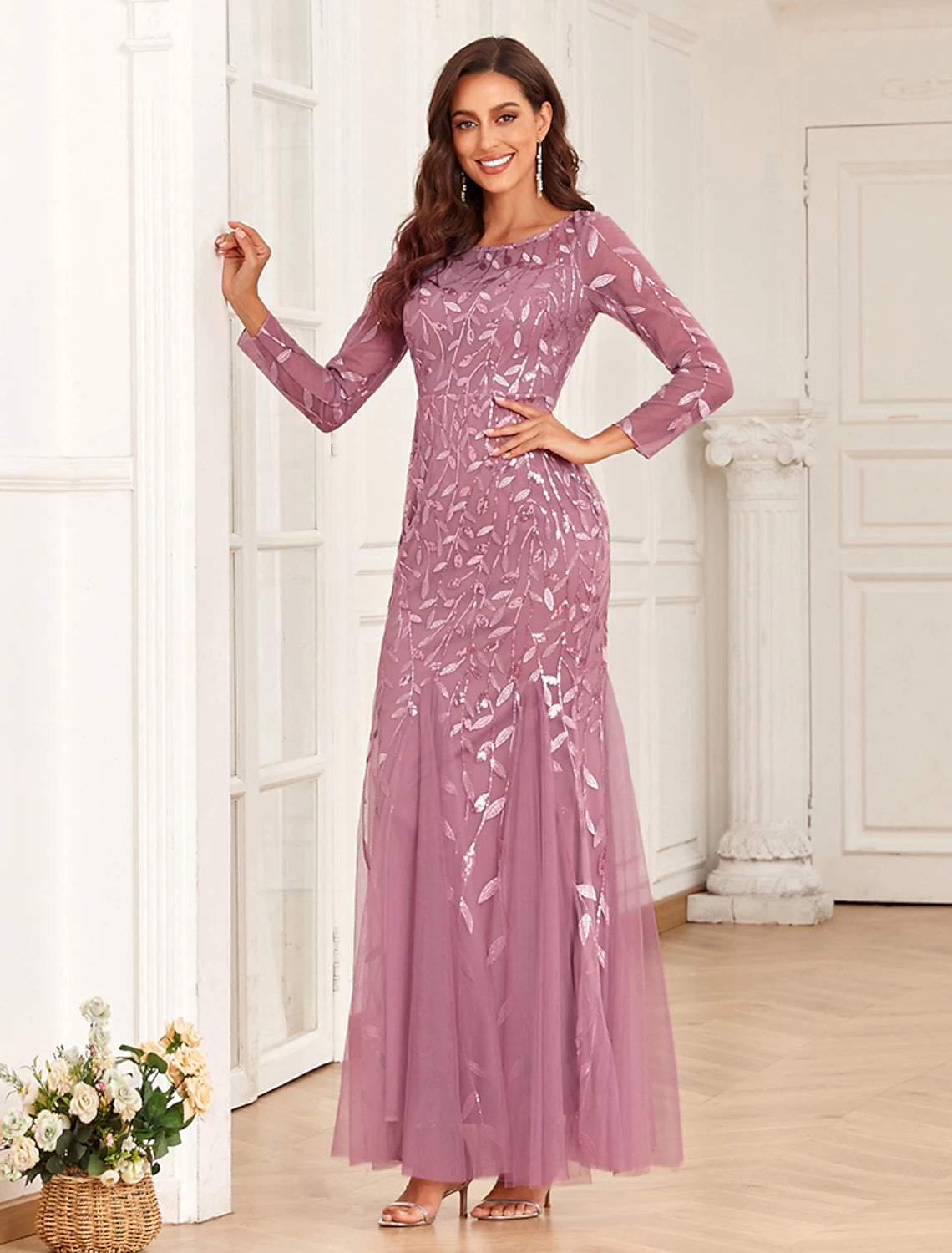 Side profile of a woman in the embroidered tulle mermaid evening gown.
