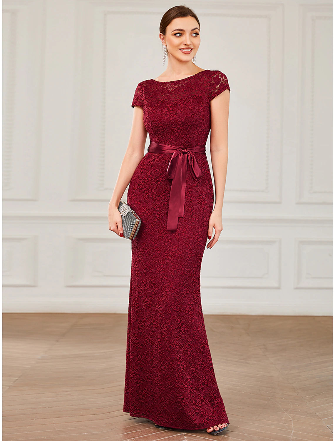A woman wearing a Weitese elegant mermaid trumpet evening gown with a jewel neck and short sleeves.