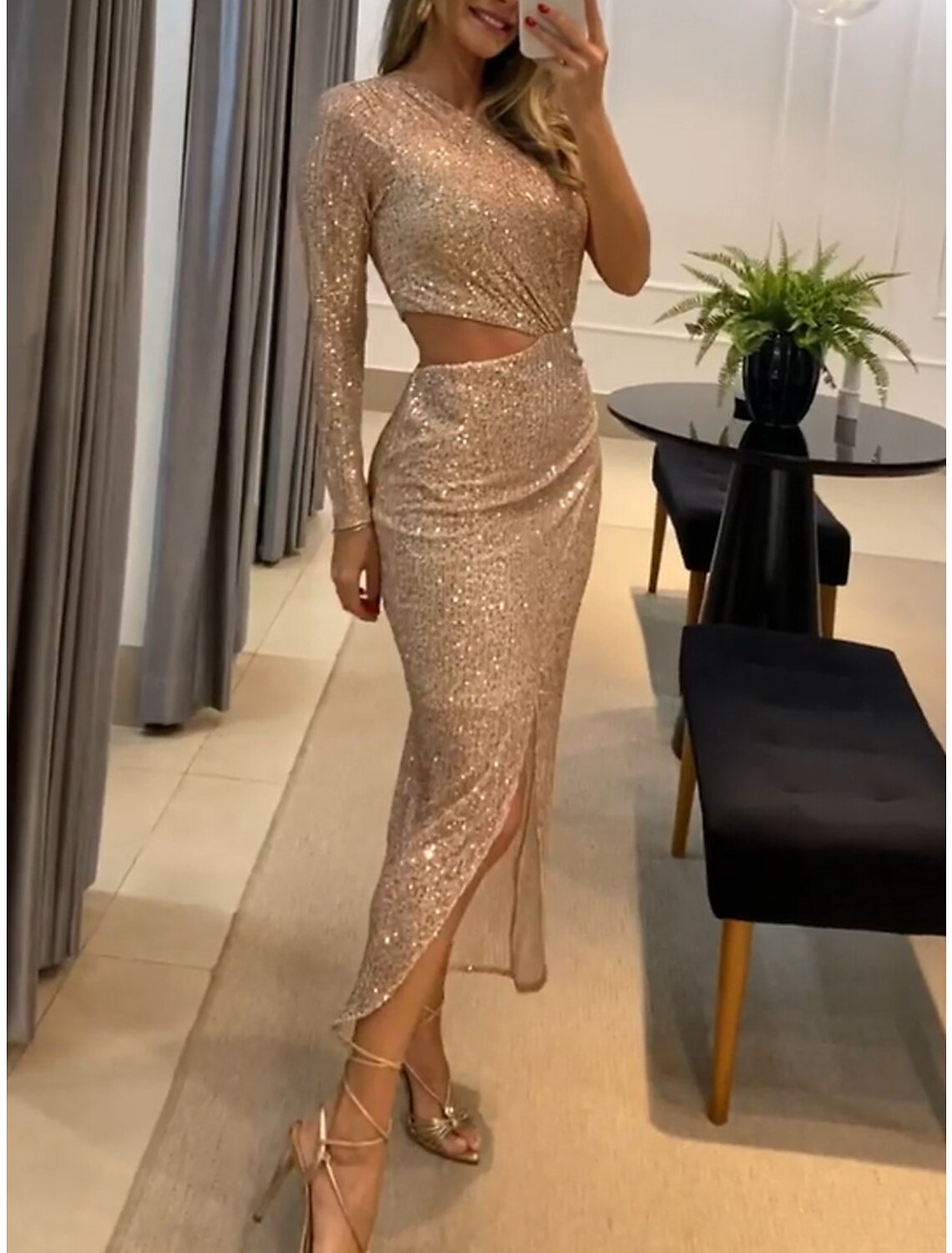 Full-length view of a woman wearing the Weitese one-shoulder long sleeve sequin gown.