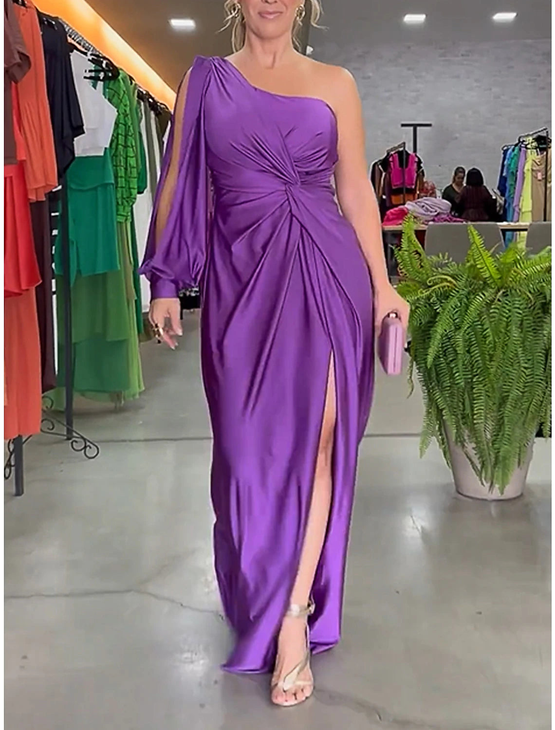 Woman wearing a purple one-shoulder ruched long-sleeve satin maxi dress.