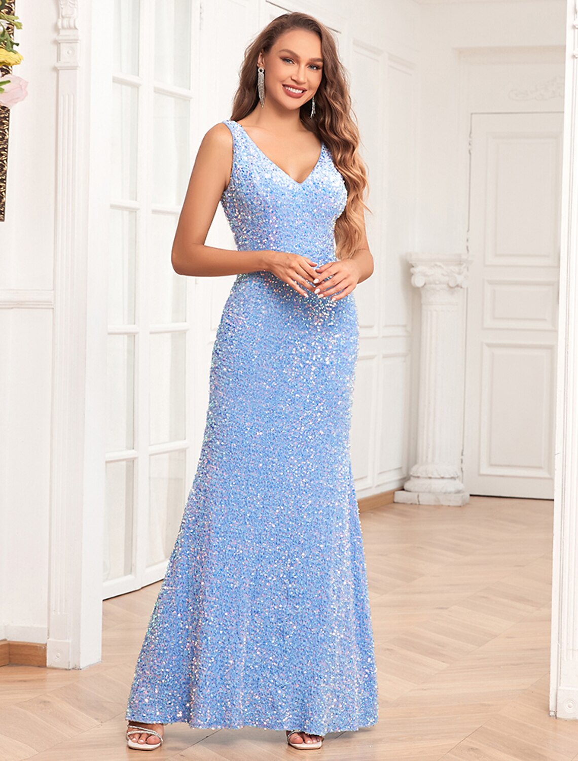 Woman wearing a sparkling sequined mermaid evening gown with a V-neck.