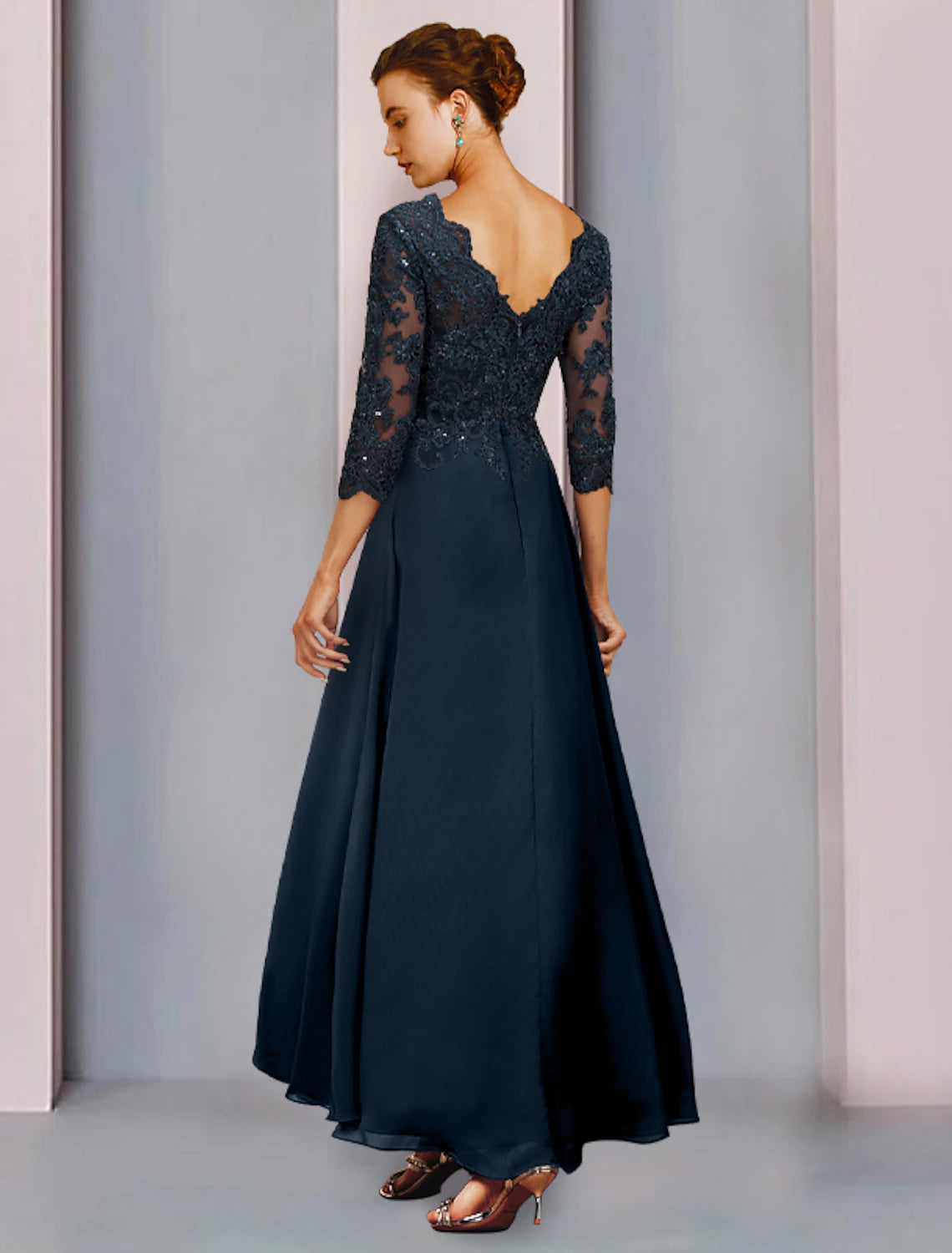 Woman modeling a sophisticated sequin and lace formal gown.