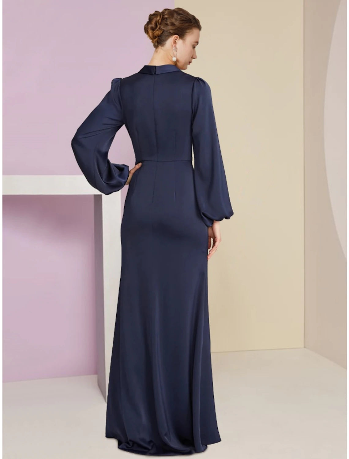 Back view of a woman in a dark long sleeve sheath column dress, showcasing the elegant fit.