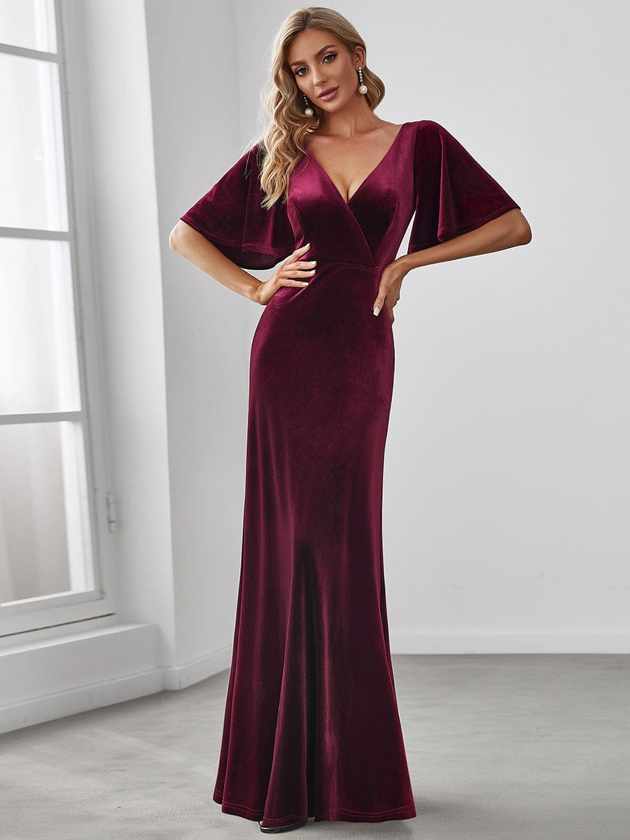 Woman wearing a rich burgundy Weitese velvet double V-neck long sleeve dress.