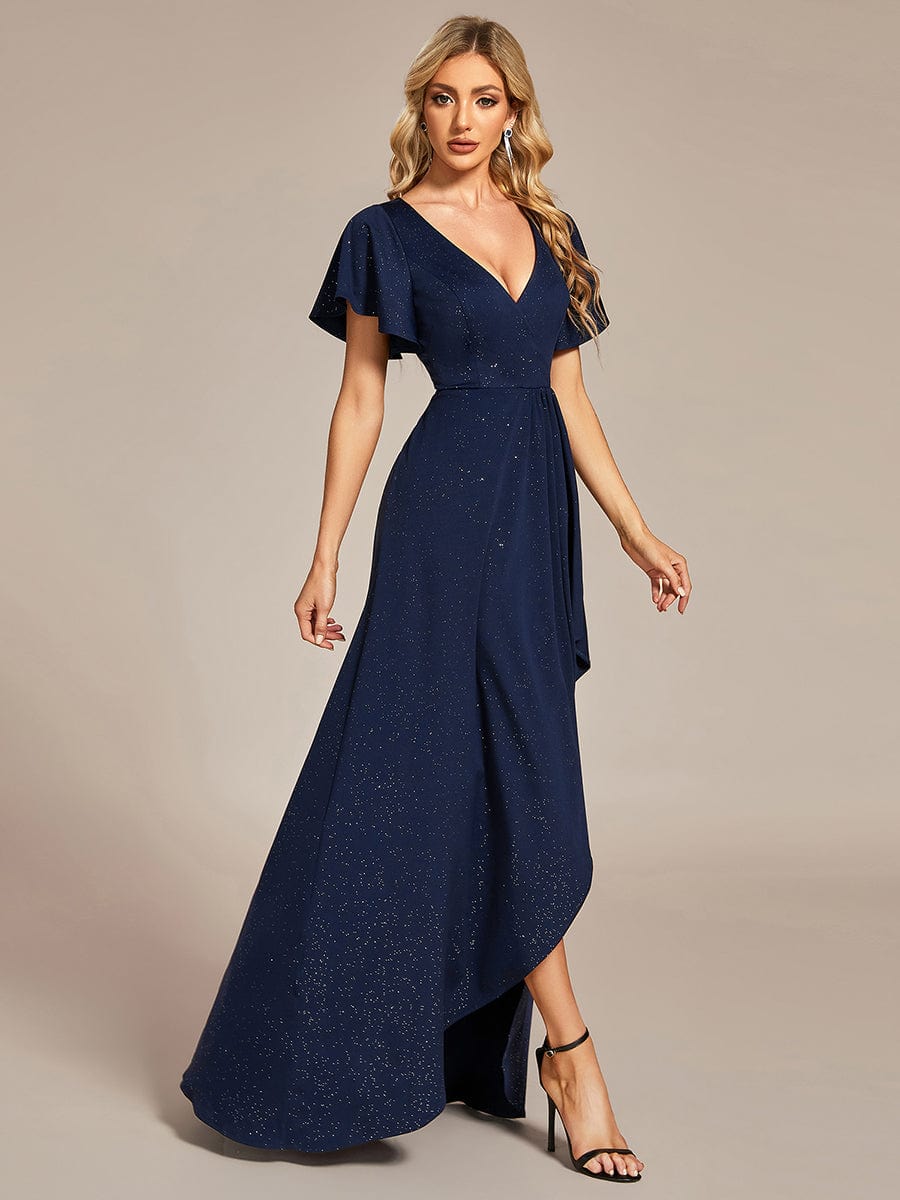Side view of a woman posing in a navy blue Weitese glitter high-low evening dress.