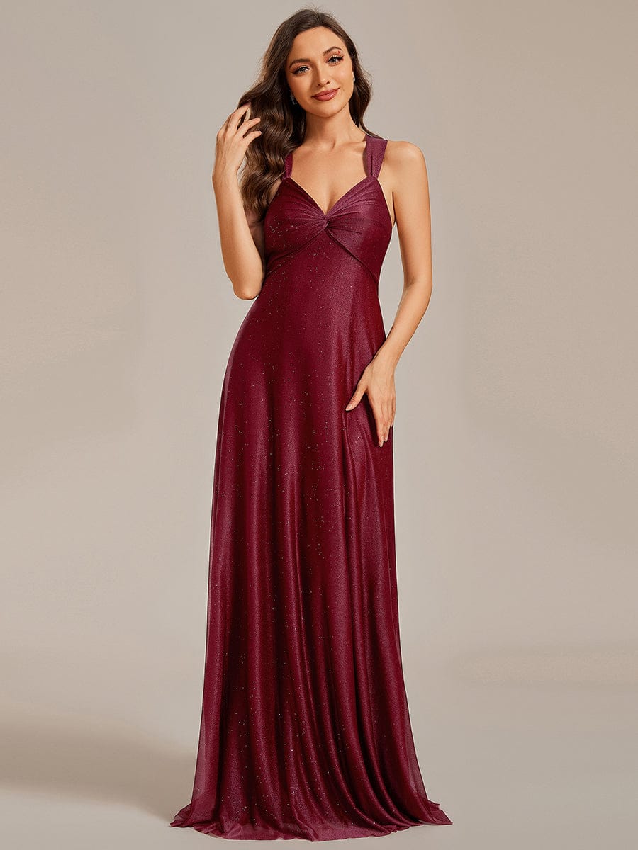 Full-length view of a woman in a glittery pleated V-neck bridesmaid dress with an adjustable lace-up back.