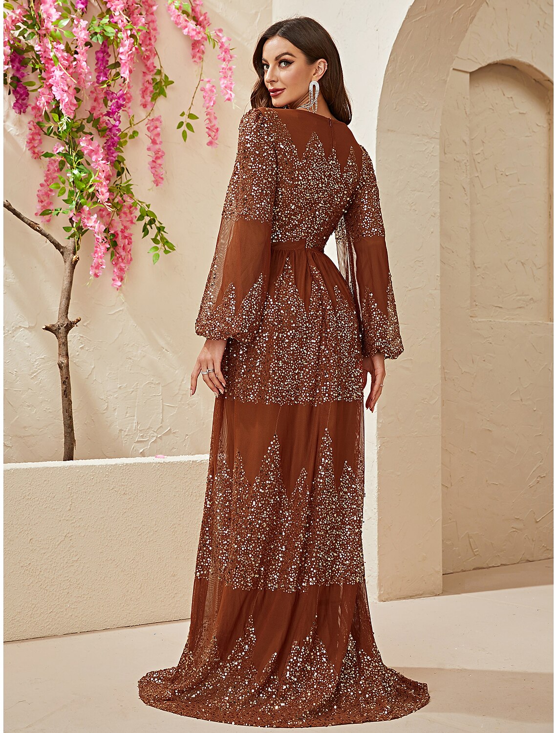 Close-up of the sparkling fabric and rhinestone detail on the long sleeve V-neck dress.