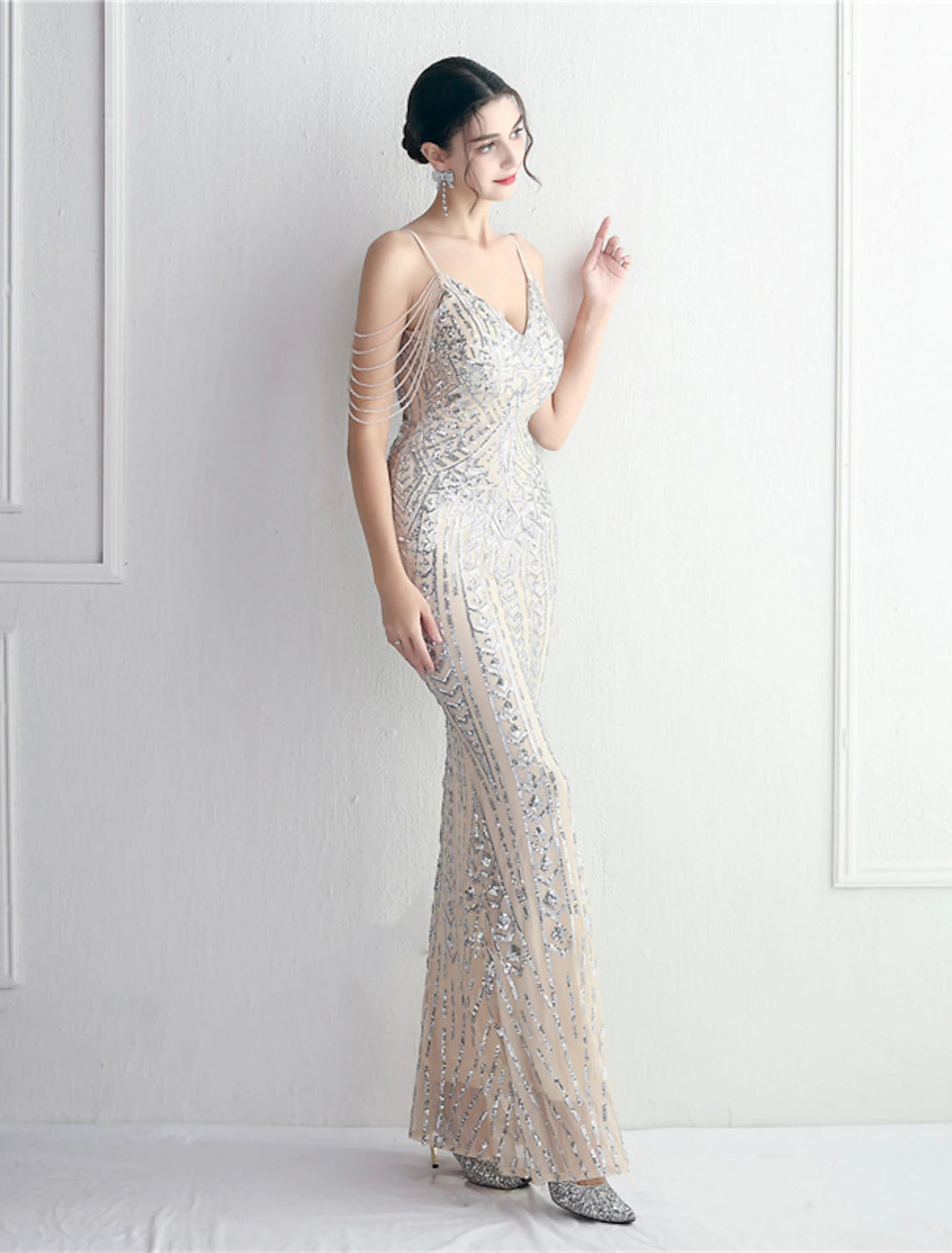Woman in a sparkling mermaid trumpet evening gown, back view, showing the train.