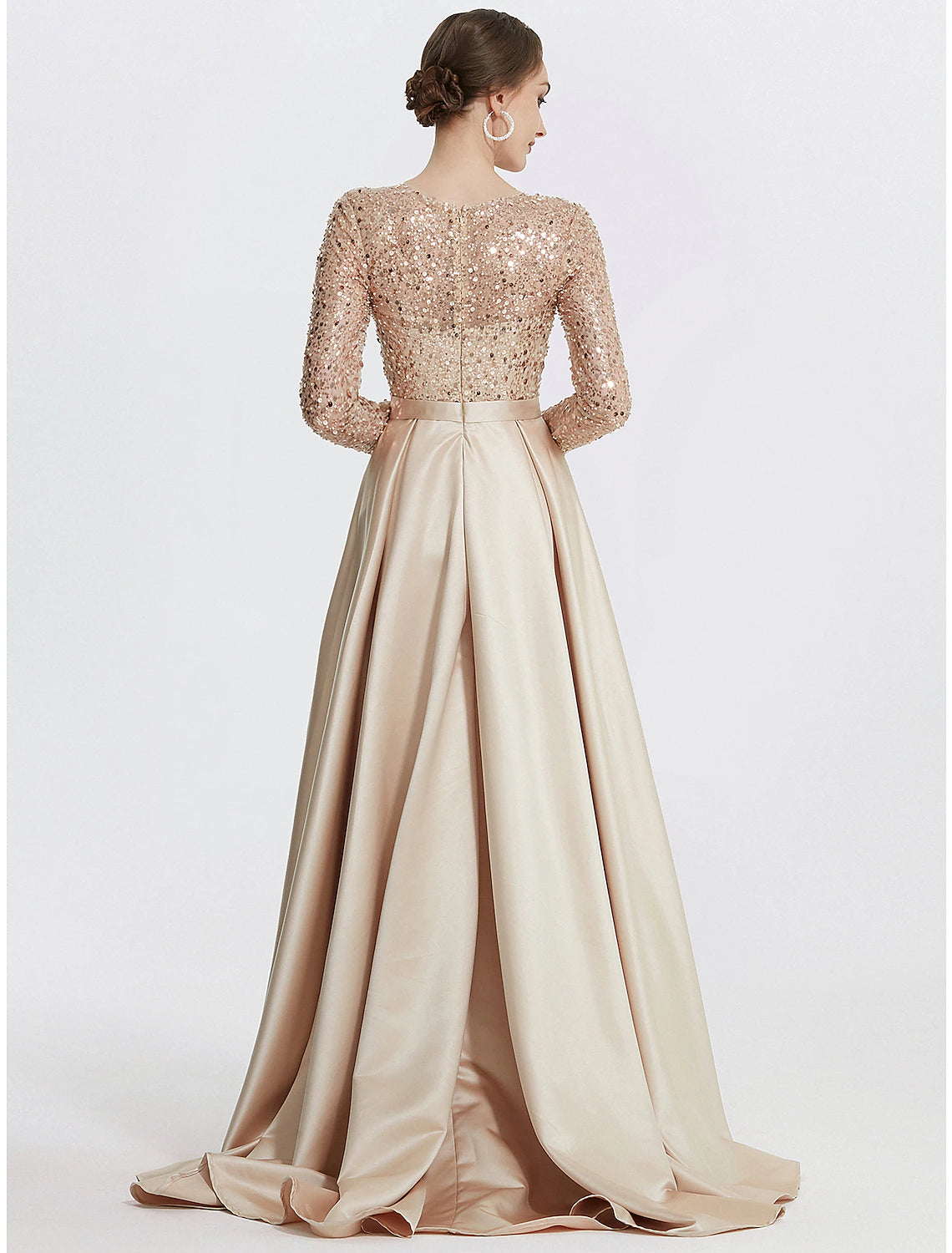 Back view of a woman in a sequined jewel neck formal dress.