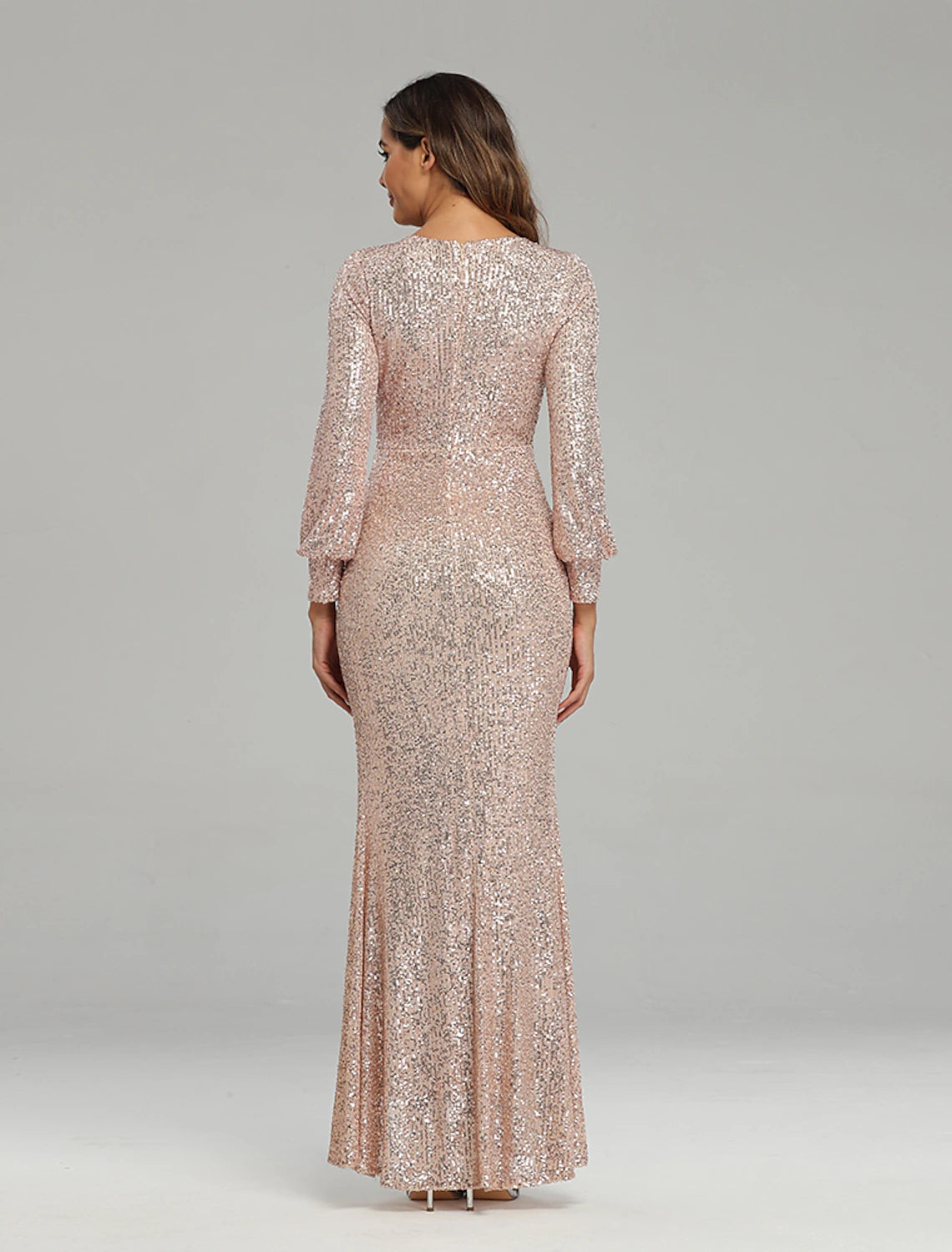 Back view of a woman in a sequined floor-length trumpet dress.