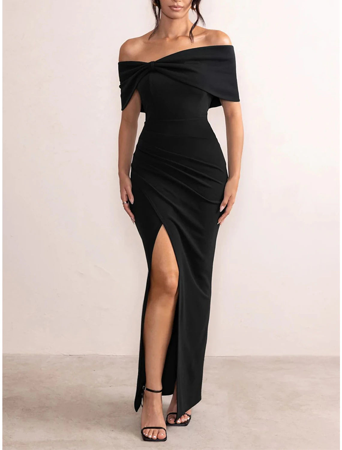 Woman wearing a black off-shoulder backless maxi dress.