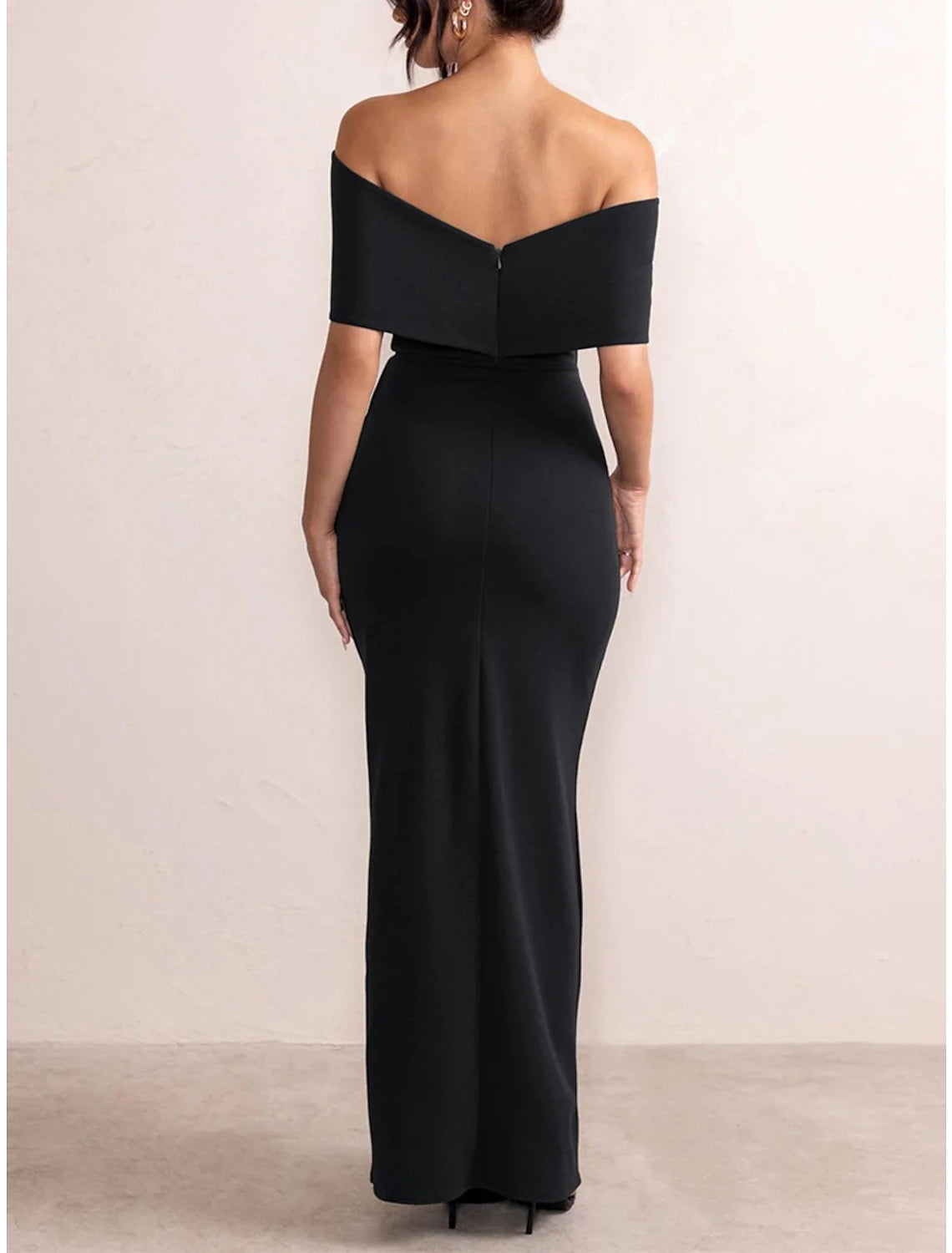 Woman wearing a red off-shoulder backless maxi dress.