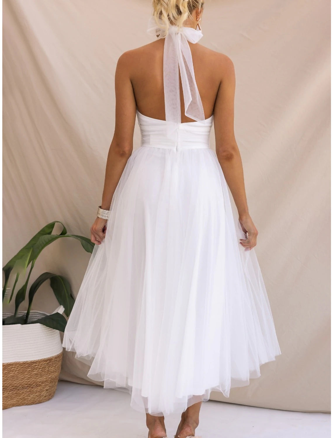 Woman wearing a graceful white Weitese halter neck mesh maxi dress.