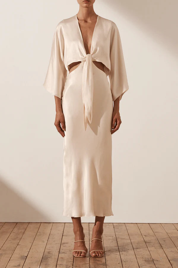 Vestido Weitese de fiesta color crema, manga 3/4, anudado, largo medio, cintura expuesta, escote en V 