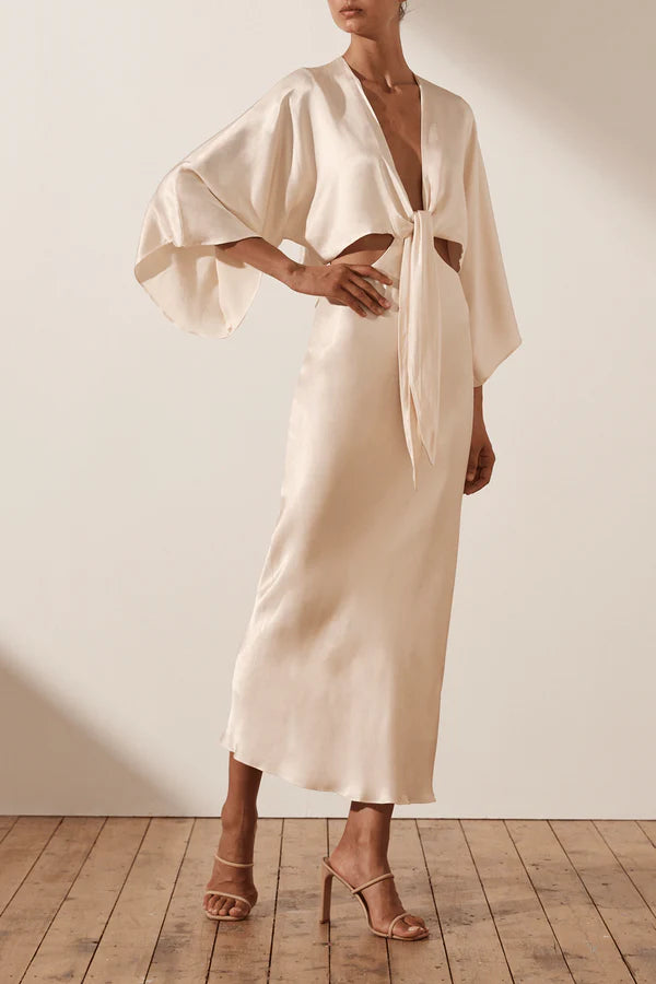 Vestido Weitese de fiesta color crema, manga 3/4, anudado, largo medio, cintura expuesta, escote en V 